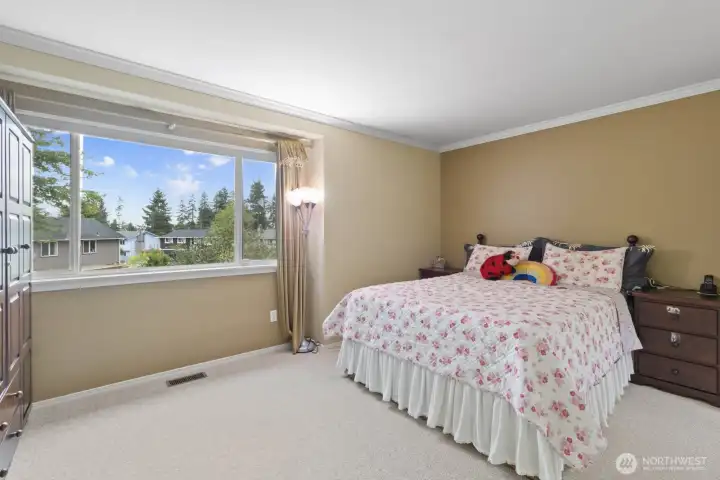 Step into the primary  suite, where stylish crown molding meets a bright box bay window, offering peaceful views of the backyard gardens.