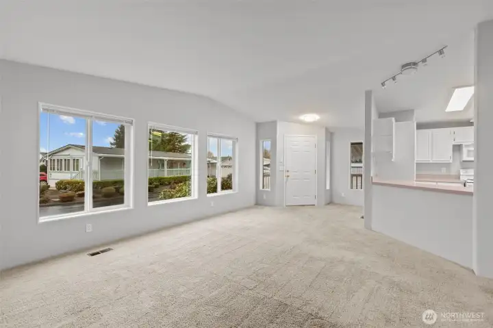 The updated lighting throughout the home sheds light on the situation, although the abundance of natural light sheds a much brighter light since there are so many windows on this light filtering side of the home.  There is a small coat closet in the entryway, just out of frame.