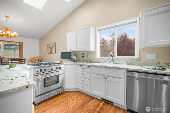Well-appointed kitchen with granite counters, eating bar, and commercial-grade BlueStar gas range.