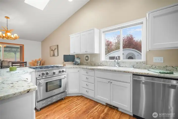Well-appointed kitchen with granite counters, eating bar, and commercial-grade BlueStar gas range.