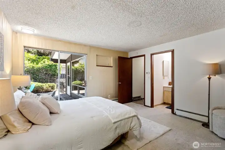 The other angle — patio access, en suite bath just through the door, radiant heat. Every base covered but the updates. A blank slate — yours to make, with brand-new carpet already in place.