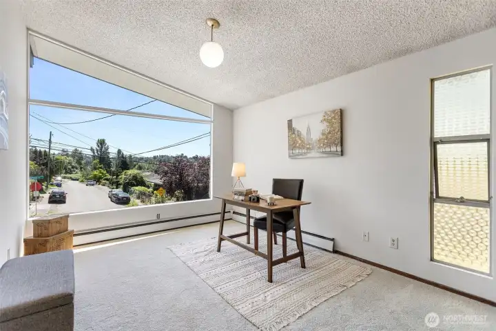 Five bedrooms and this. The front den is exceptional — vaulted ceiling, new oversized corner window with south-facing territorial views, wood-paneled wall with built-in shelving, brand-new carpet. Call it what you need it to be.