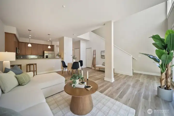 Bar seating at kitchen living room accommodates large furnishings and stairway to primary bedroom and bath.