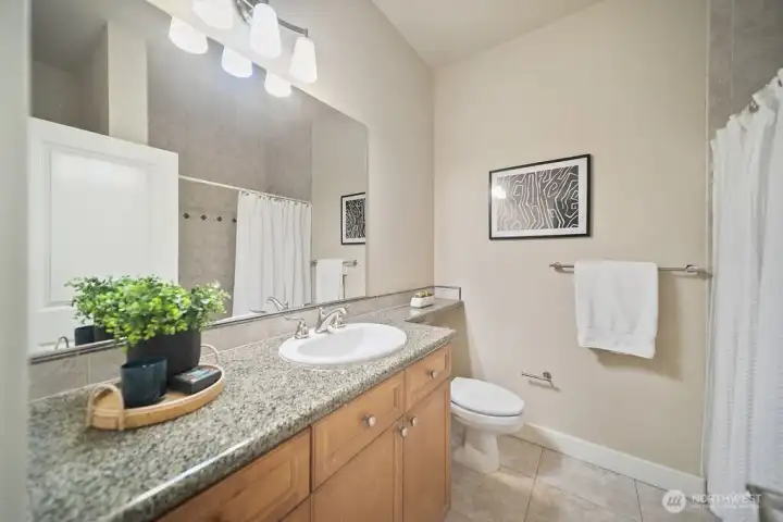 Full bath on upper level with tiled tub shower combination.