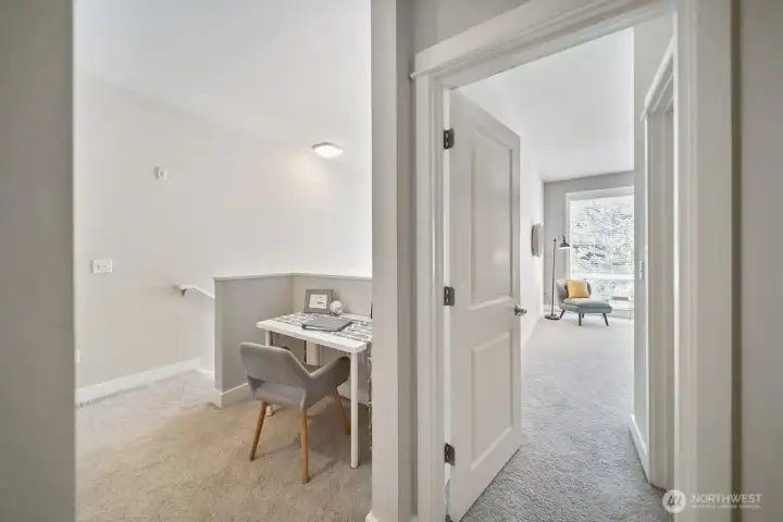 Upper hall view into bedroom and landing area.