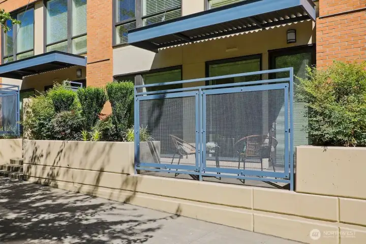 Street side unit patio is inviting on this tree lined street.
