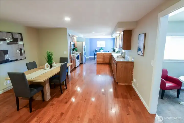 Another view of how the dining area is so conveniently open to the kitchen with eating nook in the distance. Family room is shown to the right in the this photo.