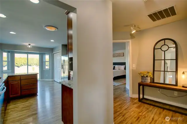 Hallway to kitchen, primary bedroom and laundry access on the right.