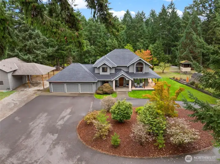 Beautiful 2.14-acre Fox Island estate with a welcoming wraparound porch, fresh exterior paint, manicured gardens, and a circular driveway. Lush landscaping and mature trees create privacy and charm from the moment you arrive.