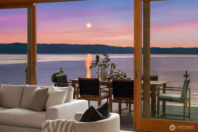 Walls of wood-cased sliding doors and picture windows open onto layers of decks and patios, extending the living space footprint.