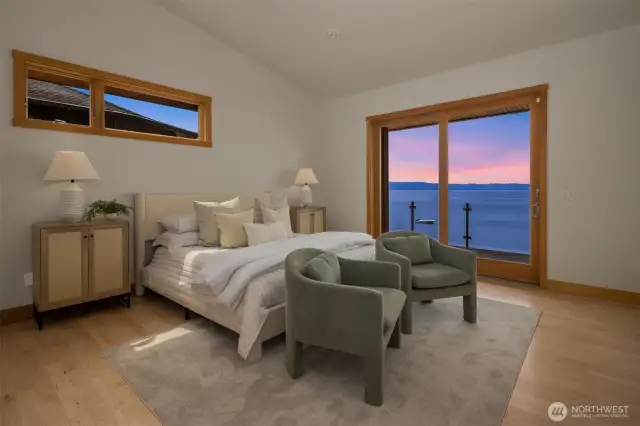 The primary suite with its vaulted ceilings and access to deck enjoys soothing water and mountain views.