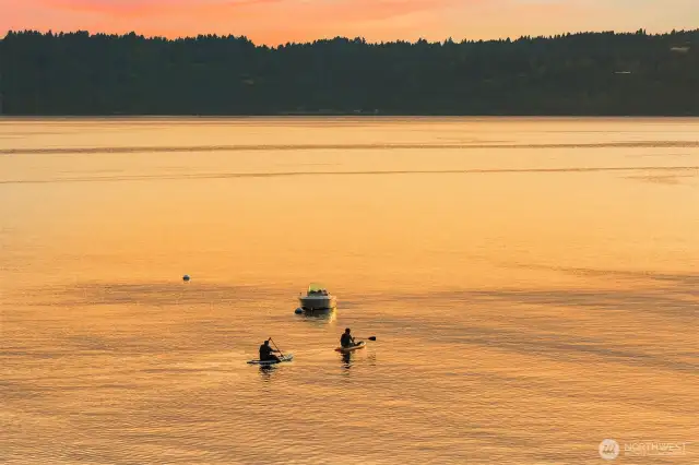 Paddle boarders enjoying a peaceful evening on the water.