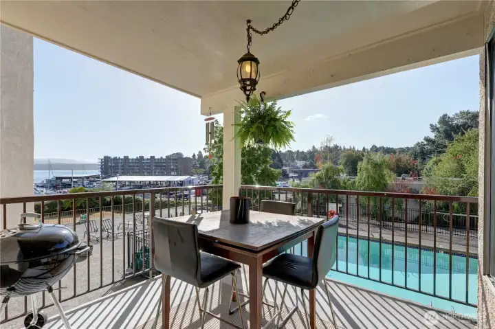 Lovely, covered deck where you can BBQ and enjoy the view overlooking the pool and Lake Washington.