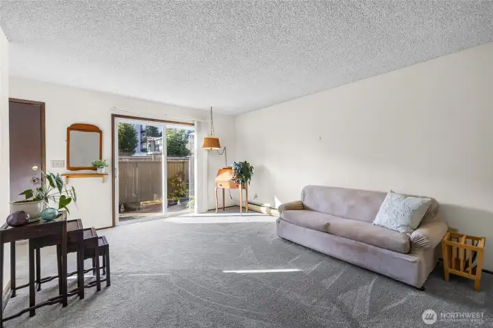 Living room with an open feel and bright exposure from the sliding door to the private fenced patio.
