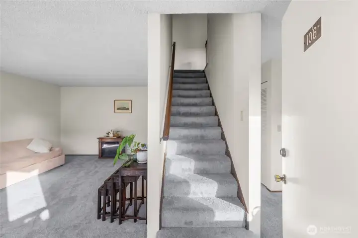 The entry opens to the stairway, with the dining room area to the right and the living room to the left.