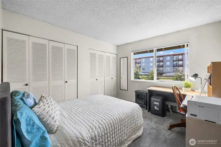 Primary bedroom window overlooking a pond, surrounding trees, and wildlife.