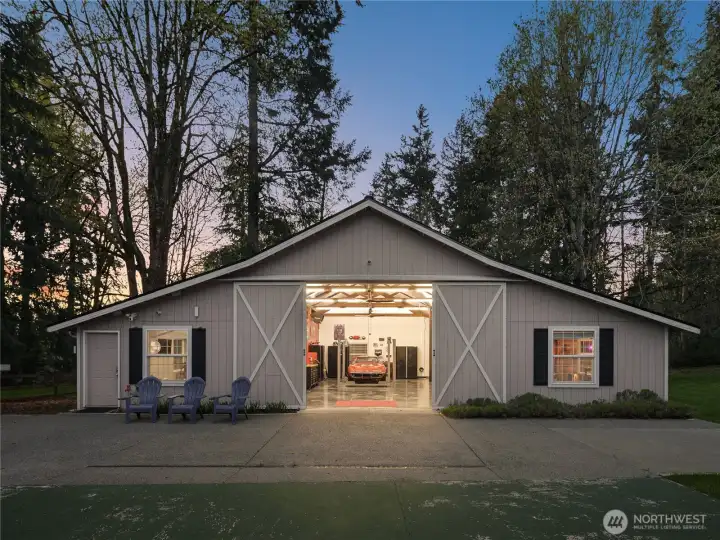 The shop is designed for comfort, featuring heating and insulation for year-round use. Extra wide barn style door with dog door. It’s wired for speakers, allowing for audio enjoyment in the garage, gym, and sitting area out front, making it a versatile space for work, exercise, and entertainment.