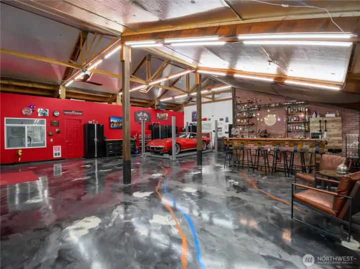 Discover your dream shop with stunning metallic epoxy floors that shine under updated LED lighting. Stay warm with a 10kW electric heater and a cozy pellet stove. Enjoy optimal airflow from two aviation-style ceiling fans. The space is wired for a 220V EV charger, making it ideal for electric vehicle enthusiasts. This shop combines style, functionality, and efficiency for the perfect work or hobby environment.