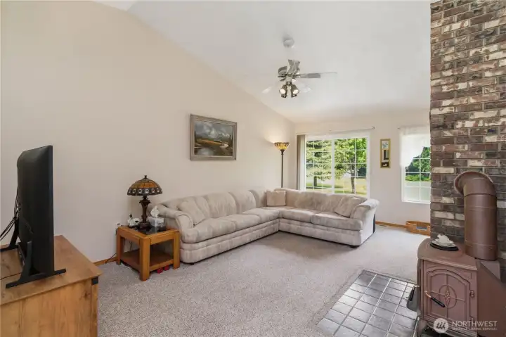 Spacious family room with pellet stove, sliding door to back deck, vaulted ceilings open to dining room.