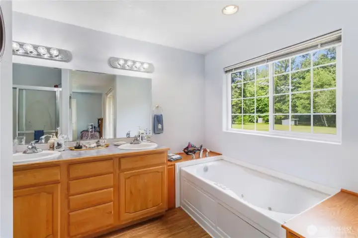 Primary ensuite bath with whirlpool tub, shower and two sinks.