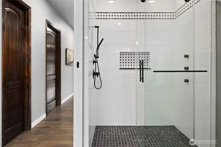 Oversized walk-in tile shower with custom glass enclosure and designer finishes elevates the spa-like feel of the primary suite. Oversized walk-in tile shower with custom glass enclosure and designer finishes elevates the spa-like feel of the primary suite.