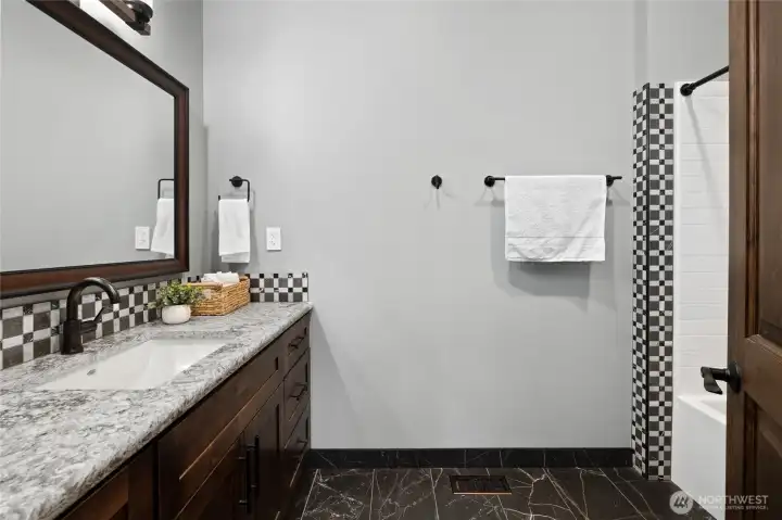 Stylish guest bathroom featuring custom finishes, quartz counters, and modern fixtures. Stylish guest bathroom featuring custom finishes, quartz counters, and modern fixtures.