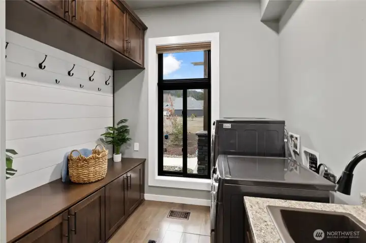 Spacious laundry and mudroom with built-in cabinetry, shiplap accents, utility sink, and abundant storage for effortless daily living. Spacious laundry and mudroom with built-in cabinetry, shiplap accents, utility sink, and abundant storage for effortless daily living.