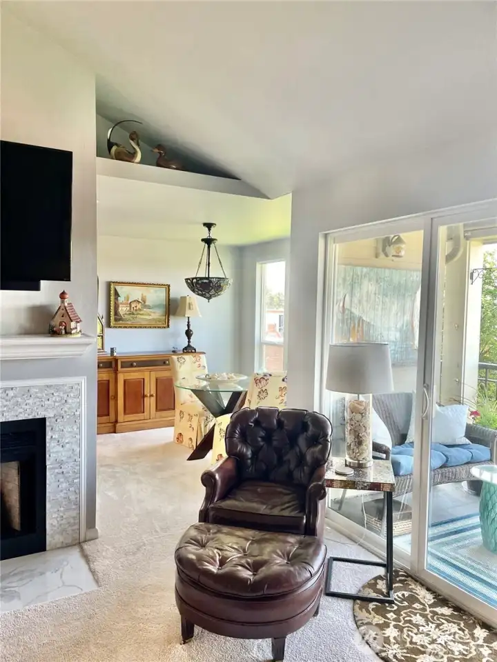A view from the living room into the dining area and a slight view of the snuggle worthy fireplace