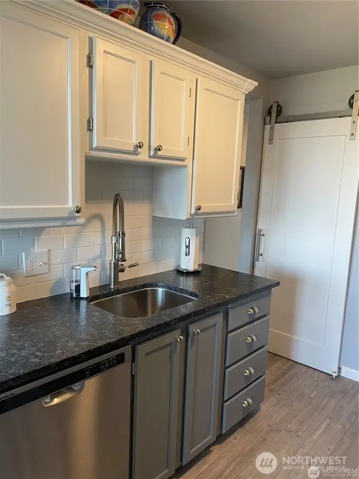 A view of one side of the kitchen with the granite counters and stainless appliances.