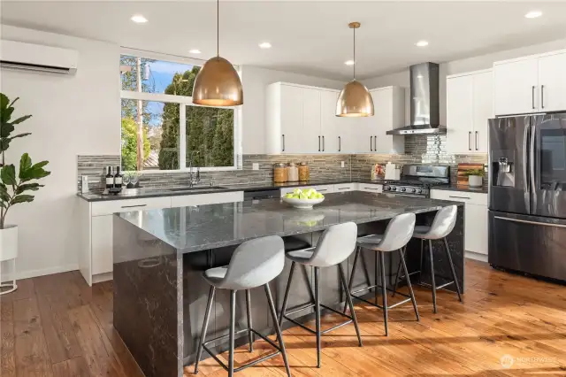 The center island features a waterfall design on the quartz counters and easily seats 4. High-end Bellmont cabinets are installed throughout the kitchen and home.