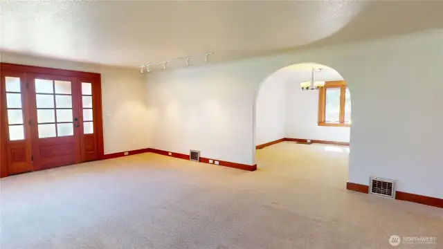 Living room looking towards front entry and arched doorway to the dining room