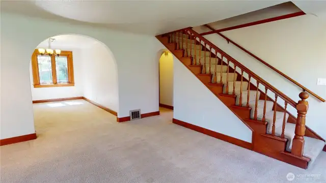 Living room looking towards arched doorway to dining room and stairs to second level