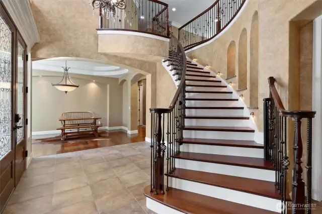 What an entry! This vaulted and open Foyer greets you and any of your guests with style and warmth. Finest materials used from Brazilian Cherry Ironwood flooring, to the lit art niches and all the arched and curving construction features!