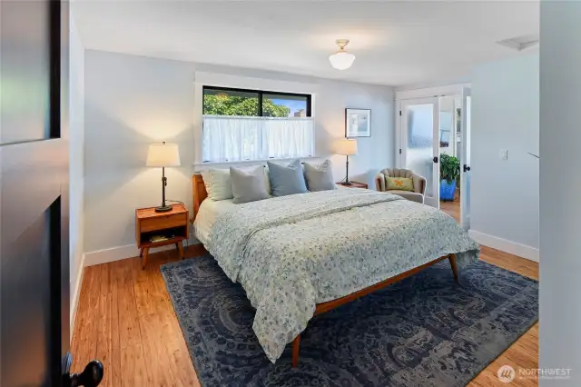 Primary bedroom has double doors to the living room, and a dressing room to the left of this photo.