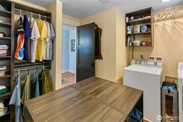 Primary bedroom dressing room includes island dressing table and washer and dryer.