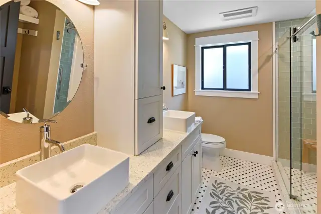 Primary/Hall 3/4 bath has high counters, double basins, and wonderful tile floor....