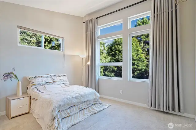 Primary bedroom with vaulted ceilings and oversized windows