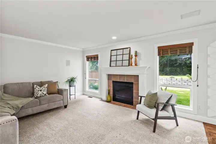 Large Living Room w/ Cozy Fireplace and Large Windows Overlooking the Backyard