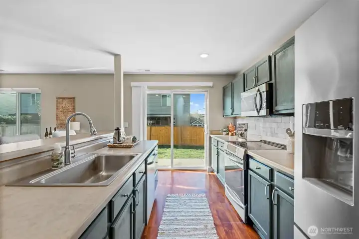 Kitchen steps out to patio and fully fenced yard