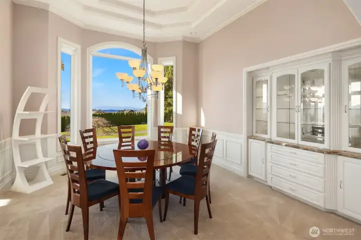 Spacious Dining Room with a westerly view to the Olympics, 12' high designer ceiling and a Custom Lighted China Hutch!