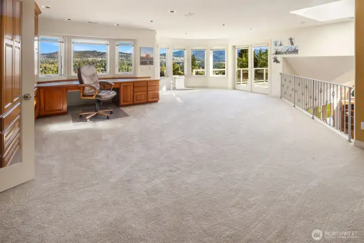 Amazing second floor loft with terrific views, built in desk and cabinetry, French doors to a rooftop deck and railing overlooking the family room