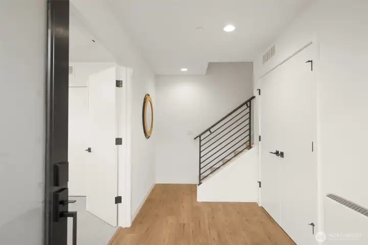 Bright, open-concept entryway featuring contemporary finishes and a sleek staircase.