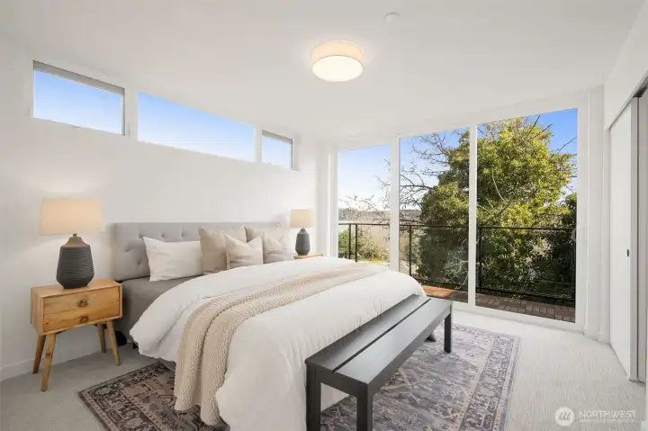 Serene primary bedroom suite with large windows and a clean, minimalist design.