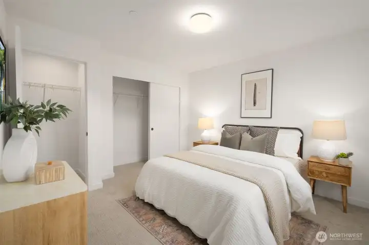 Spacious secondary bedroom featuring plush carpeting and large, light-filled windows.