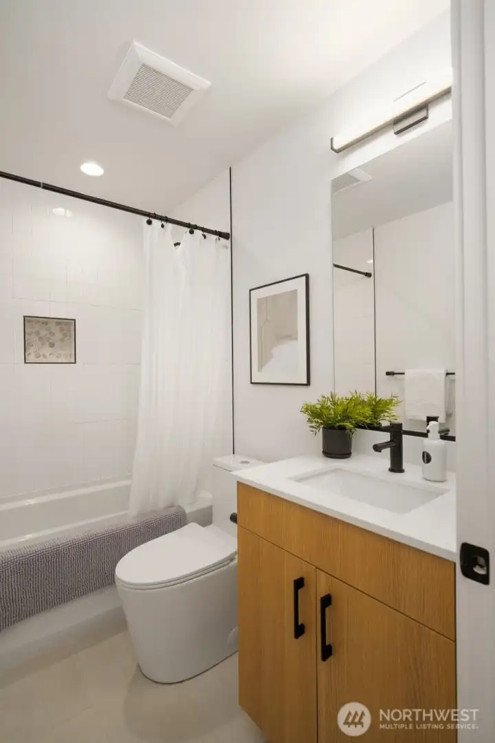 Full guest bathroom with clean, contemporary fixtures and vanity storage.