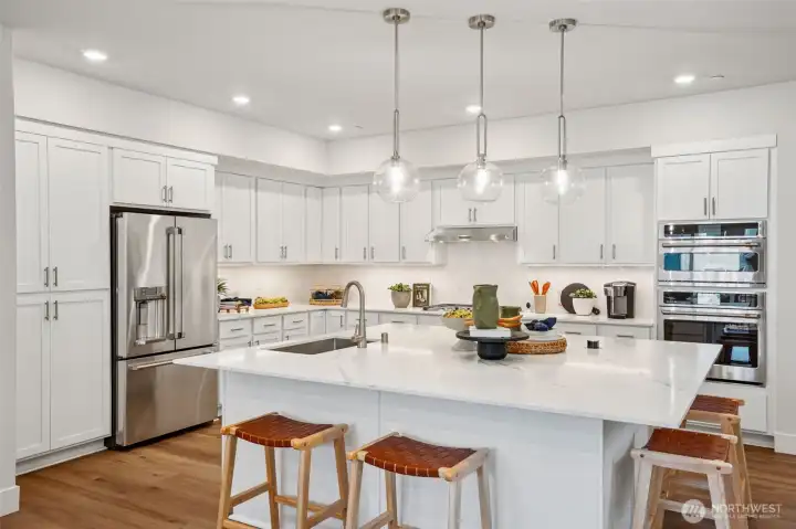 Massive Open Kitchen with our largest island.  Plenty of cabinets, drawers all on soft closed hinges.  Beautiful white painted HUNTWOOD cabinets.  GE cafe' Drop in gas 5-burner stove, wall microwave & oven, dishwasher and