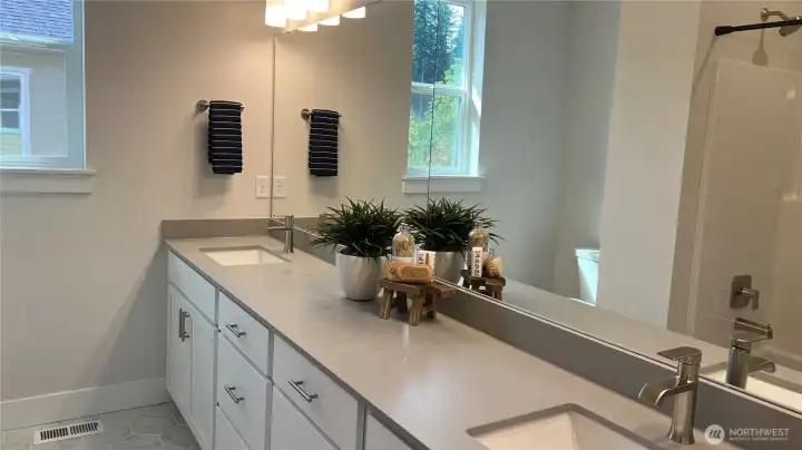 Upstairs main bath, dual sinks, tile floor.