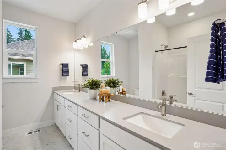 Upper bathroom. Dual sinks, quartz counters, tub/shower combo and tiled floors.