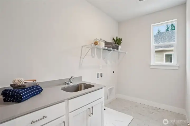 Large laundry room w/operable window.  Large counter, sink and cabinets.