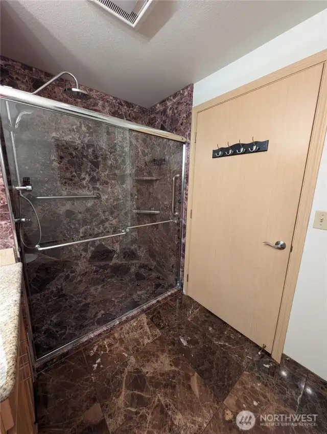 Double shower heads with marble tile.